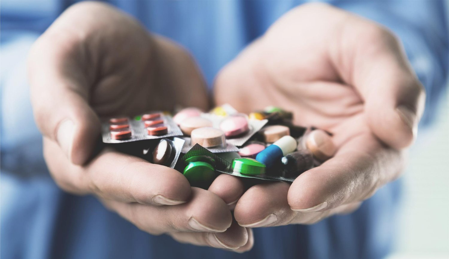 hands with colorful pills tablets